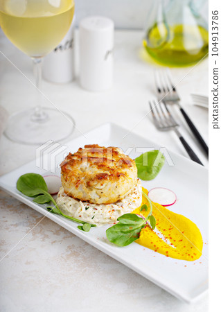 Gourmet plated fishcake with vegetables 104913786