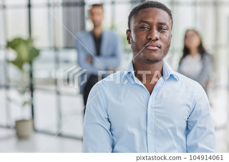 African American businessman in a blue shirt looking at the camera African American businessman in a blue shirt looking at the camera 104914061