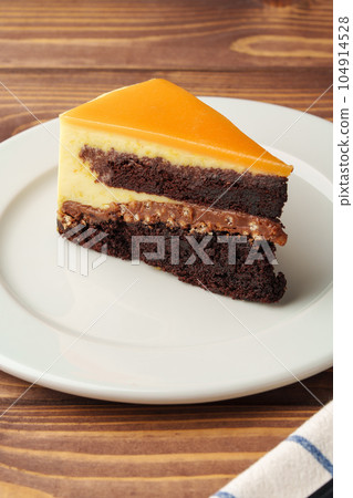 Delicious chocolate cake in white plate on wooden table background Delicious chocolate cake in white plate on wooden table background 104914528