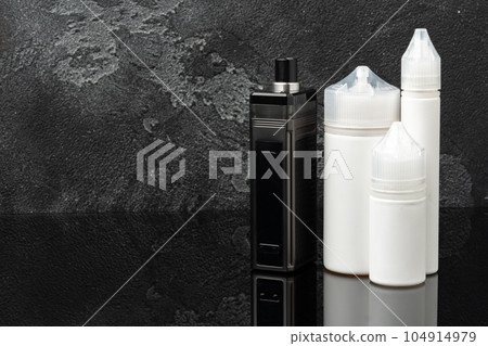 Electronic cigarette with re-fill liquid bottles on gray background 104914979