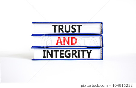 Trust and integrity symbol. Concept words Trust and integrity on books. Beautiful white table white background. Business, psychological and trust and integrity concept. Copy space. 104915232