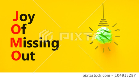 JOMO joy of missing out symbol. Concept words JOMO joy of missing out on beautiful yellow background. Green light bulb icon. Light bulb icon. Business JOMO joy of missing out concept. Copy space. JOMO joy of missing out symbol. Concept words JOMO joy of missing out on beautiful yellow background. Green light bulb icon. Light bulb icon. Business JOMO joy of missing out concept. Copy space. 104915287