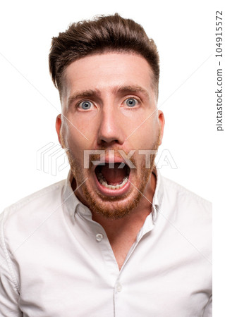 Vertical shot of stupefied stunned shocked young male keeps mouth widely opened, being surprised and very emotional, expresses great surprisment. 104915572