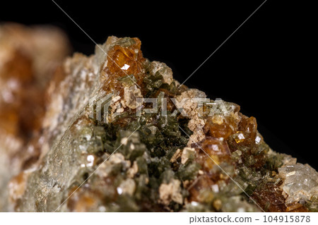 macro mineral stone Grossular, Garnet, Epidote on a black background macro mineral stone Grossular, Garnet, Epidote on a black background 104915878