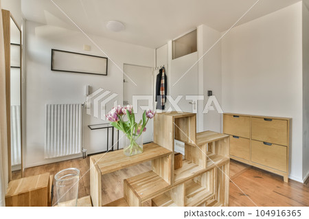 a wooden table and chairs in a room with white walls, light wood flooring and large mirror on the wall a wooden table and chairs in a room with white walls, light wood flooring and large mirror on the wall 104916365
