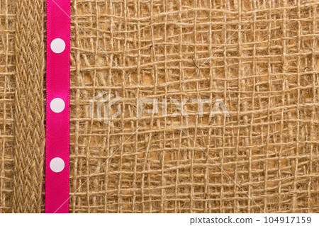 Dot ribbon on burlap cloth background Dot ribbon on burlap cloth background 104917159