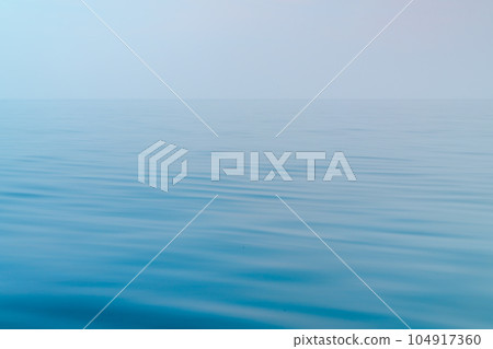 Blue sea with gentle waves and a sky, a peaceful ocean with small waves that are pleasing to the eye 104917360
