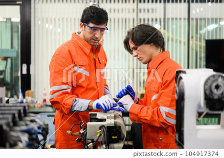 Engineers working and solving problems on machine at industrial plant Engineers working and solving problems on machine at industrial plant 104917374