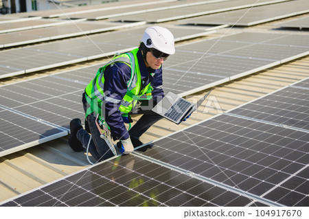 Engineers with safety helmet checking solar system at solar power farm Engineers with safety helmet checking solar system at solar power farm 104917670