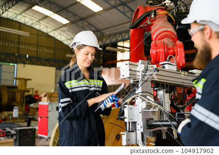 Mechanical engineers repairing engine machine at factory 104917902