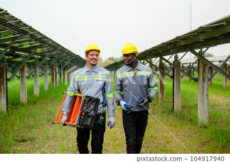 Professional engineers maintaining solar panels on solar cell farm 104917940