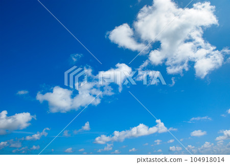 White fluffy clouds and bright sun on blue sky. White fluffy clouds and bright sun on blue sky. 104918014