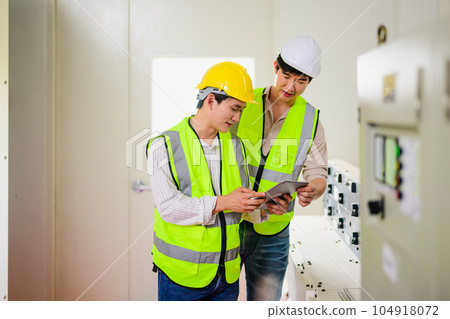 Maintenance engineer maintaining solar panels on solar cell farm Maintenance engineer maintaining solar panels on solar cell farm 104918072