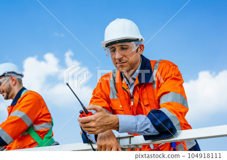 Professional engineers technicians working at wind turbine farm field Professional engineers technicians working at wind turbine farm field 104918111