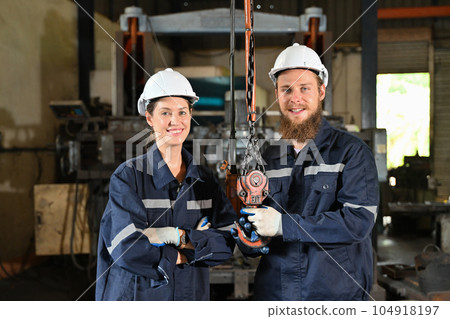 Mechanical engineers repairing engine machine at factory 104918197