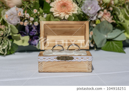 wedding ring pillow burlap in wooden box in front of flower bouquet rings of love 104918251