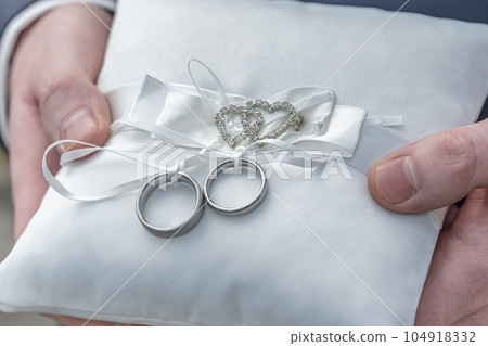Two wedding rings on a ceremonial cushion pillow beautifull decorated 104918332