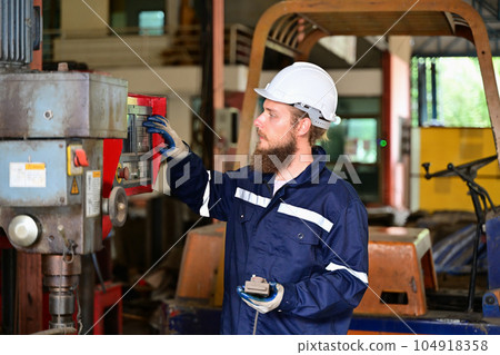 Mechanical engineer repairing engine machine at factory 104918358