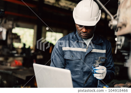 Professional male industrial worker in white hard hat working at manufacturing 104918466