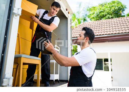 Happy two delivery men in front of delivery truck, Delivery men checking order of moving service and relocation service 104918535