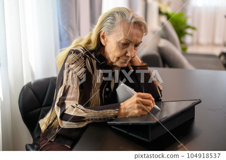 Portrait of happy senior woman smiling and sitting on sofa at home 104918537