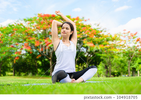Healthy young woman enjoying and relaxing yoga outdoor in green park Healthy young woman enjoying and relaxing yoga outdoor in green park 104918705
