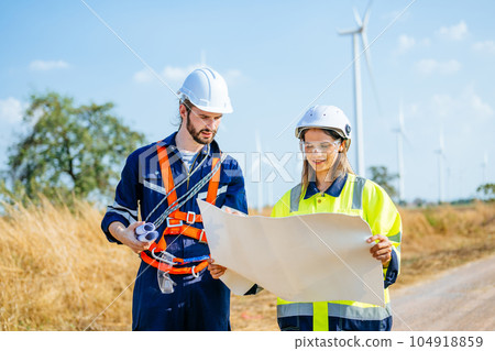 Professional engineers technicians working at wind turbine farm field Professional engineers technicians working at wind turbine farm field 104918859