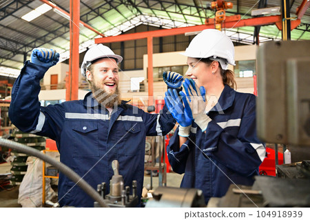 Mechanical engineers repairing engine machine at factory 104918939