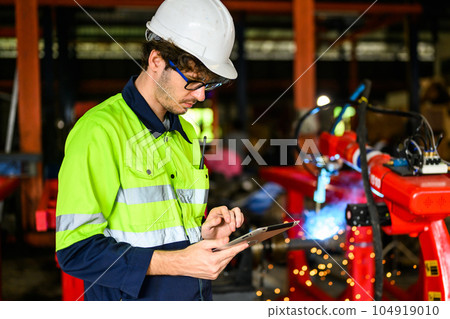 Young mechanical technician using tablet checking machine at warehouse Young mechanical technician using tablet checking machine at warehouse 104919010