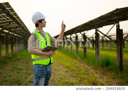 Maintenance engineer installing solar panels on solar cell farm 104919020