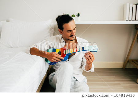 Happy gay man spending time at home, People relaxing and resting at modern house, People lifestyle, Man with music Happy gay man spending time at home, People relaxing and resting at modern house, People lifestyle, Man with music 104919436