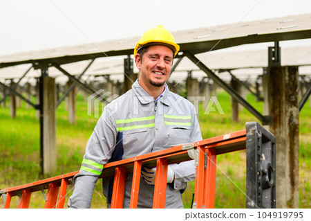 Maintenance technician checking solar panels on solar cell farm 104919795