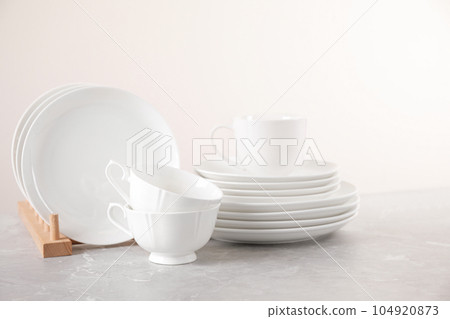 Set of clean tableware on light grey marble table 104920873