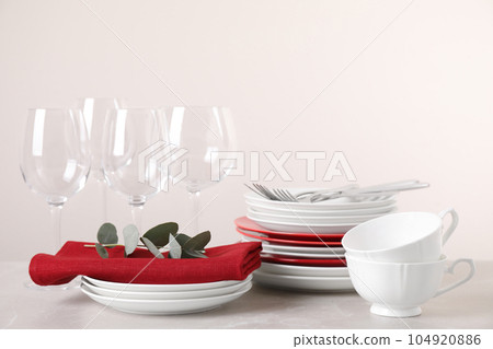 Set of clean tableware on light grey marble table 104920886