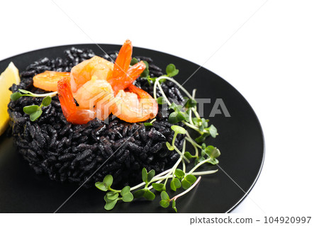 Delicious black risotto with shrimps isolated on white, closeup Delicious black risotto with shrimps isolated on white, closeup 104920997
