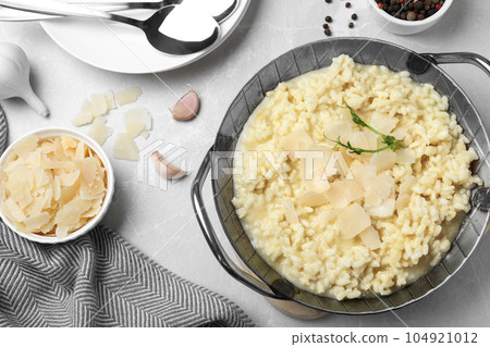 Delicious risotto with cheese on grey marble table, flat lay Delicious risotto with cheese on grey marble table, flat lay 104921012