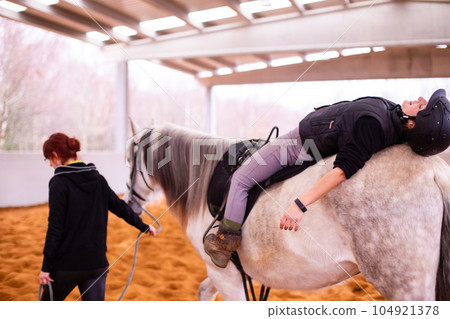 Hippotherapy. Therapeutic wellness, occupational therapy mid-adult woman patient on horse school Hippotherapy. Therapeutic wellness, occupational therapy mid-adult woman patient on horse school 104921378