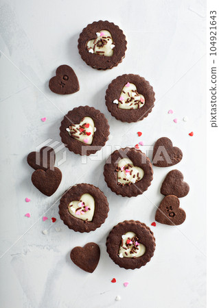 Heart shaped chocolate cookies with cream filling Heart shaped chocolate cookies with cream filling 104921643