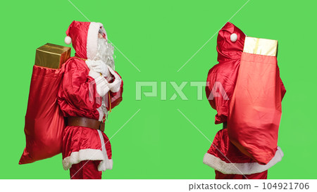 Saint nick waiting for something to give presents and toys from red bag, man dressed like santa claus during seasonal holiday. Young adult in costume carrying sack with many gifts. Saint nick waiting for something to give presents and toys from red bag, man dressed like santa claus during seasonal holiday. Young adult in costume carrying sack with many gifts. 104921706