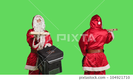 Man in costume delivering pizza in thermal backpack, portraying festive seasonal character in red suit over greenscreen background. December holiday celebration, bearded deliveryman. 104921710