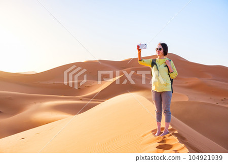 在撒哈拉沙漠拍照的女人 104921939