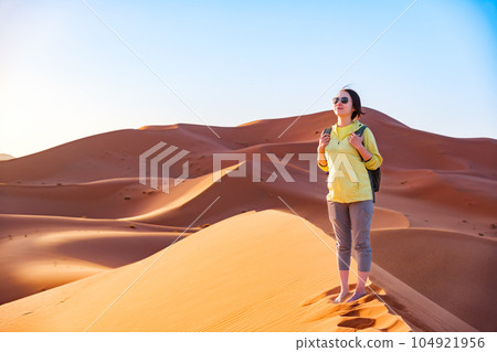 Woman traveling in the Sahara Desert Woman traveling in the Sahara Desert 104921956