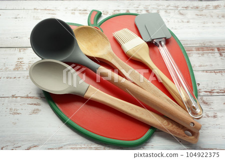 wooden cutlery fork and spoon on a chopping board on table  104922375