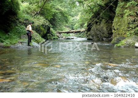 Senior man enjoying lure fishing in mountain stream Senior man enjoying lure fishing in mountain stream 104922410