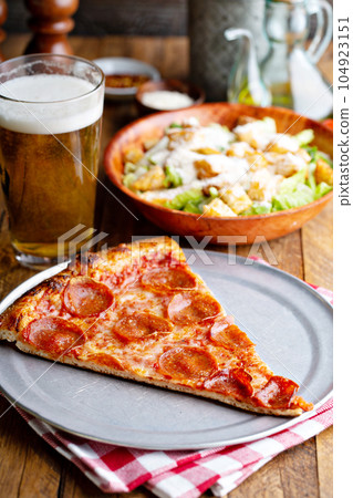 Pepperoni pizza slice with a side salad 104923151