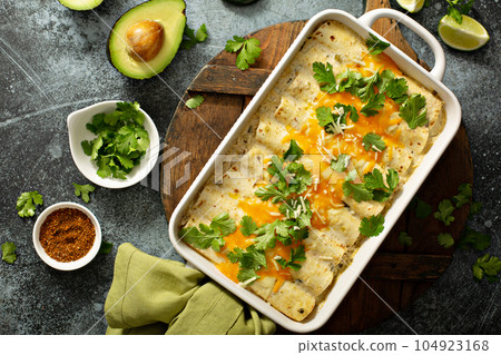 Green enchiladas casserole in a baking dish 104923168