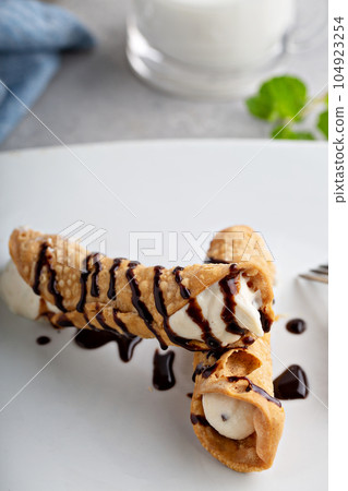 Italian dessert canolli with ricotta filling 104923254