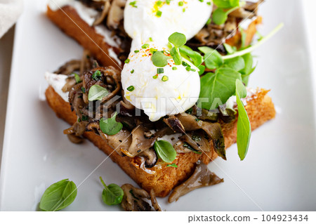 Breakfast toast with mushrooms and poached eggs Breakfast toast with mushrooms and poached eggs 104923434