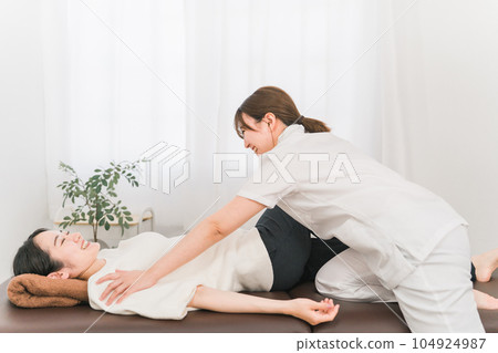 A manipulative woman massaging a patient A manipulative woman massaging a patient 104924987