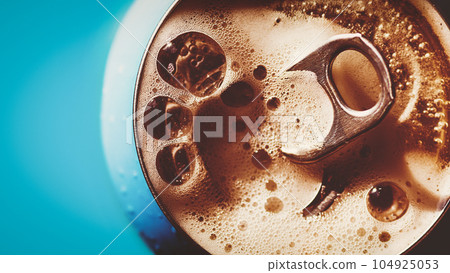 Frothing beer, cola or energy drink from open can, top view, copy space Frothing beer, cola or energy drink from open can, top view, copy space 104925053